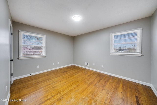 spare room with a wealth of natural light and light hardwood / wood-style flooring