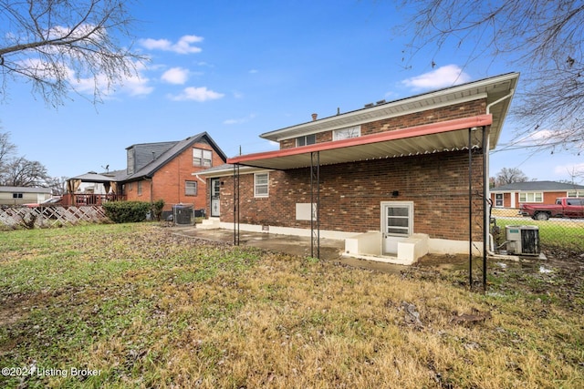 back of property with a patio, a yard, and central air condition unit