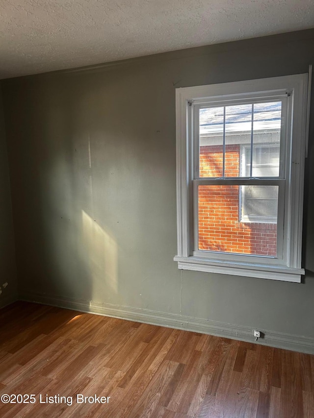 unfurnished room featuring hardwood / wood-style floors and a textured ceiling