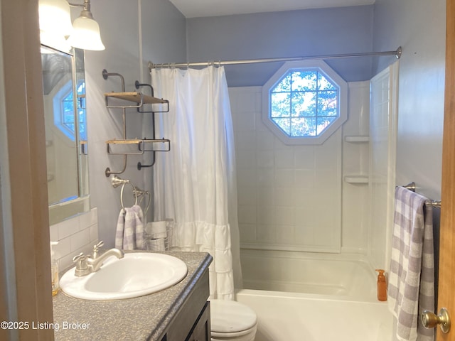 full bathroom with vanity, shower / tub combo with curtain, and toilet