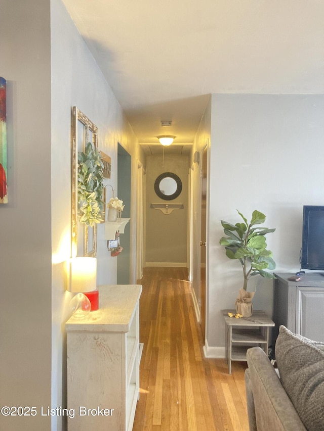 corridor with hardwood / wood-style flooring