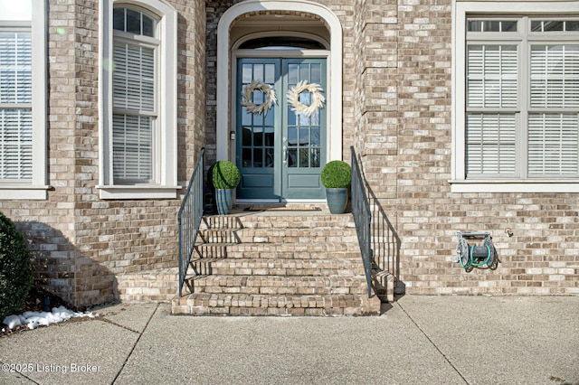 doorway to property featuring french doors and brick siding