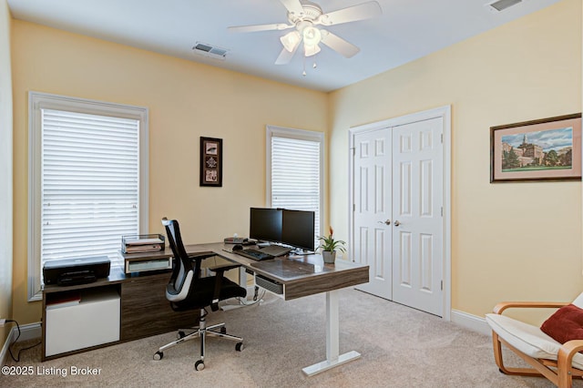 home office with light carpet, baseboards, visible vents, and a ceiling fan