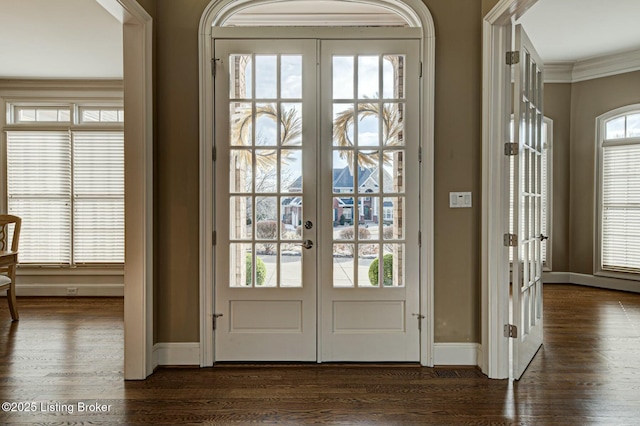 doorway with crown molding, baseboards, dark wood-style flooring, and french doors