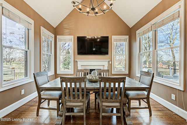 dining room with lofted ceiling, baseboards, and wood finished floors