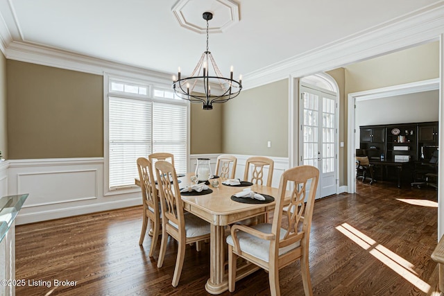 dining area with french doors, a wainscoted wall, crown molding, and dark wood-style flooring