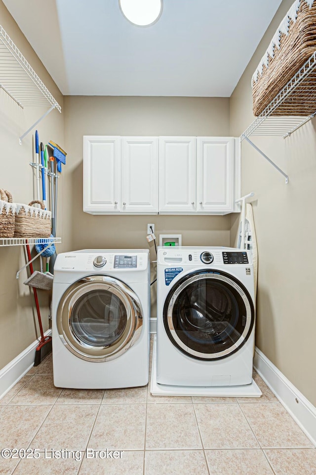 laundry room featuring washer and dryer, cabinet space, baseboards, and light tile patterned floors