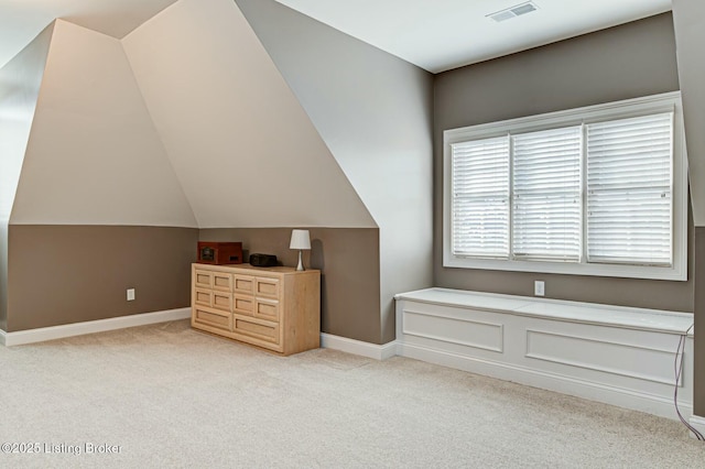 additional living space featuring lofted ceiling, baseboards, visible vents, and light colored carpet