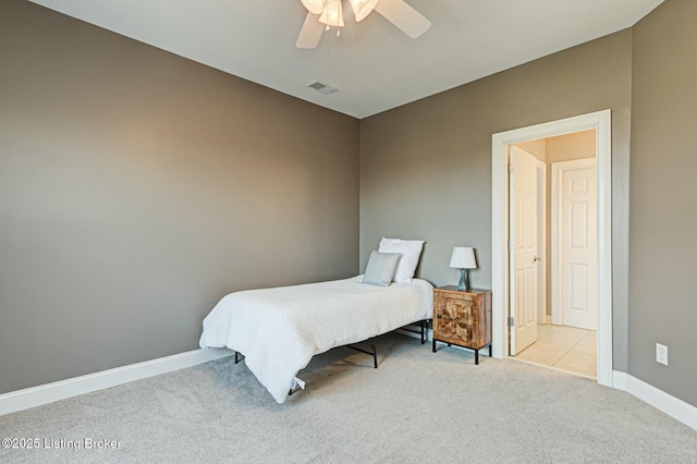 bedroom with baseboards, a ceiling fan, visible vents, and light colored carpet