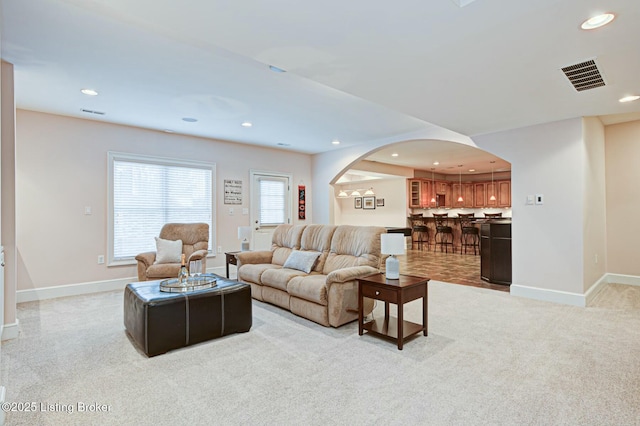 living room featuring a healthy amount of sunlight, baseboards, and visible vents