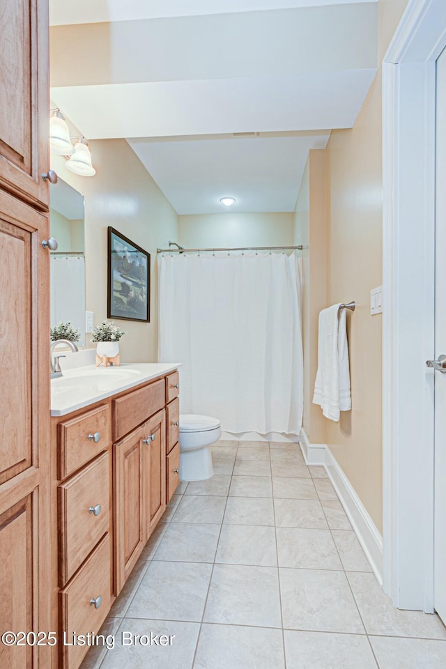 bathroom featuring tile patterned flooring, baseboards, vanity, and toilet