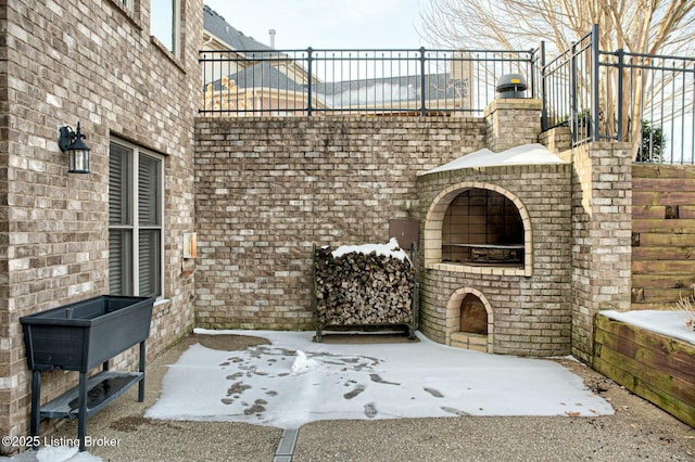 snow covered patio featuring a fireplace