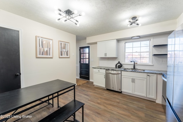 kitchen featuring dishwasher, light stone countertops, sink, and white cabinets