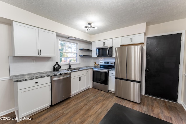 kitchen featuring appliances with stainless steel finishes, dark hardwood / wood-style floors, sink, and white cabinets