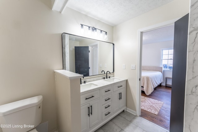 bathroom with vanity, toilet, and a textured ceiling