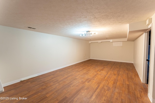 empty room featuring hardwood / wood-style flooring and a textured ceiling