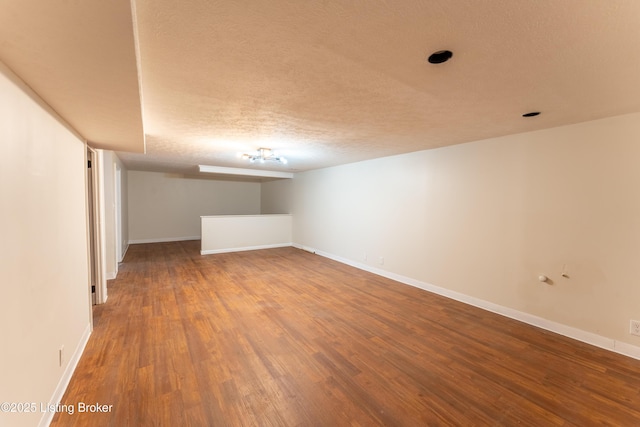 basement featuring hardwood / wood-style floors and a textured ceiling