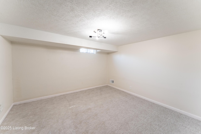 basement featuring carpet and a textured ceiling