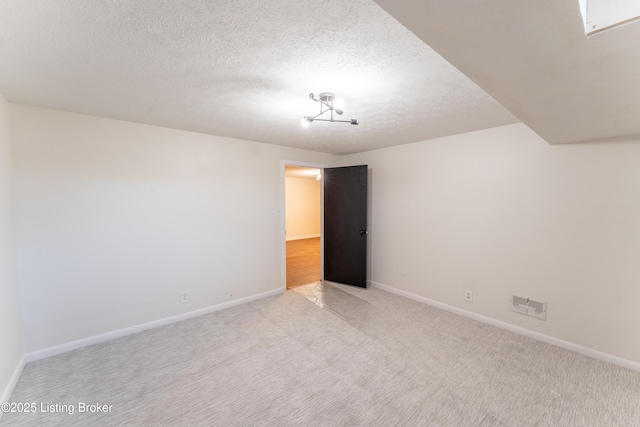 unfurnished room featuring light carpet and a textured ceiling