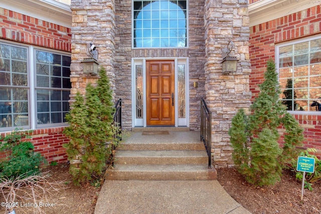 entrance to property featuring stone siding and brick siding