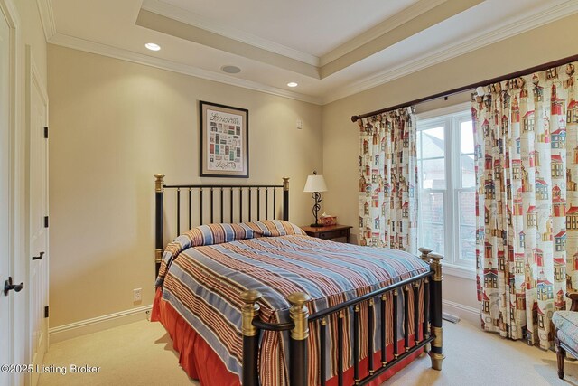 bedroom with light carpet, a tray ceiling, multiple windows, and baseboards