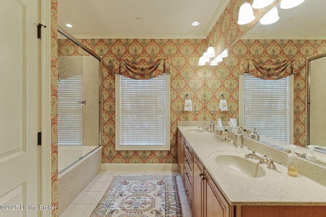 full bathroom featuring wallpapered walls, crown molding, a sink, and tile patterned floors