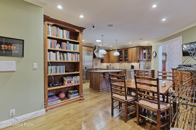 dining space with light wood-style floors, baseboards, crown molding, and recessed lighting