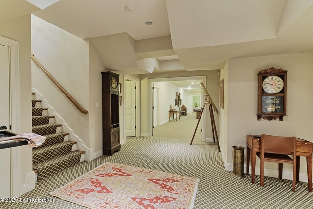 hallway with stairs, light carpet, and baseboards