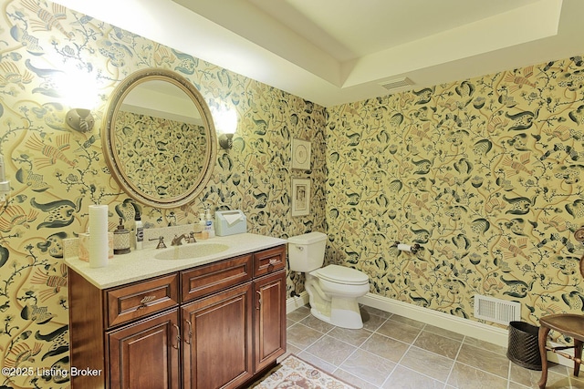 bathroom with wallpapered walls, visible vents, and a tray ceiling