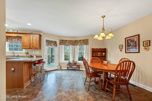 dining space featuring a chandelier and sink