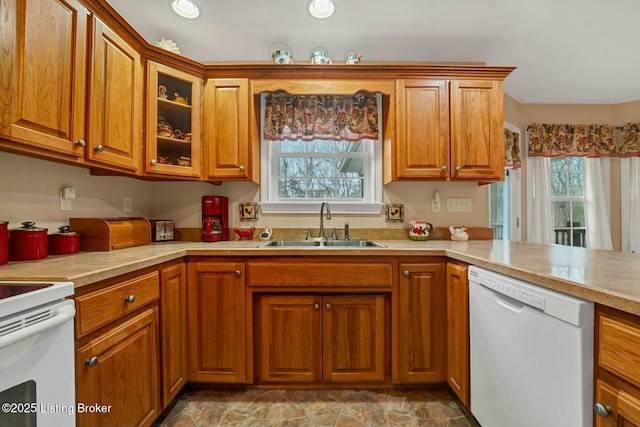 kitchen featuring white appliances, kitchen peninsula, and sink