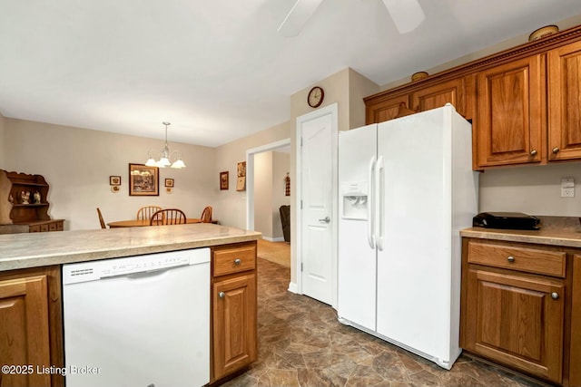 kitchen featuring an inviting chandelier, white appliances, and decorative light fixtures