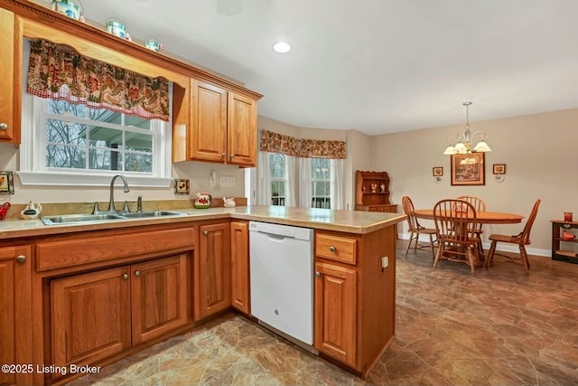 kitchen with decorative light fixtures, dishwasher, sink, a notable chandelier, and kitchen peninsula