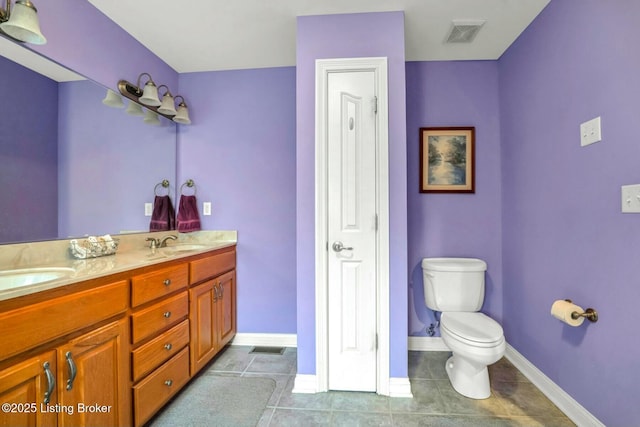 bathroom featuring vanity, tile patterned flooring, and toilet