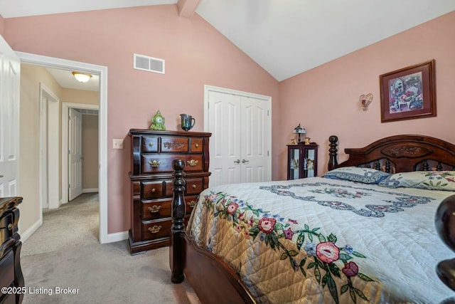 bedroom with lofted ceiling with beams, light colored carpet, and a closet