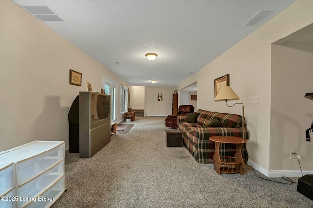 carpeted living room featuring a textured ceiling