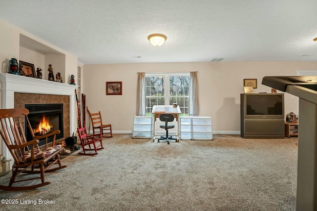 office area featuring carpet flooring, a fireplace, and a textured ceiling