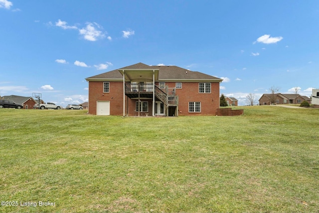 rear view of house featuring a garage, a yard, and a deck