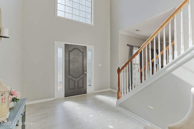 foyer featuring a high ceiling and crown molding