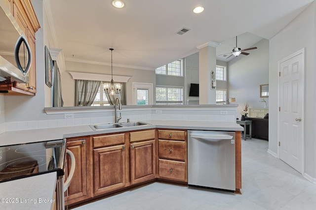 kitchen with hanging light fixtures, appliances with stainless steel finishes, sink, and a wealth of natural light