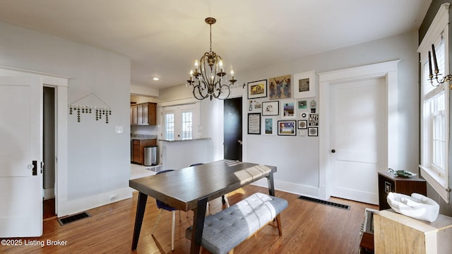 dining room with wood-type flooring and a chandelier