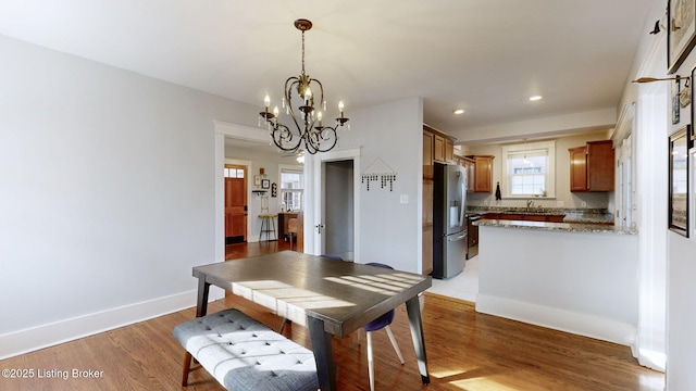 dining area featuring an inviting chandelier and light hardwood / wood-style flooring