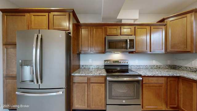 kitchen featuring appliances with stainless steel finishes and light stone countertops