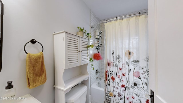 bathroom with shower / bath combination with curtain and toilet