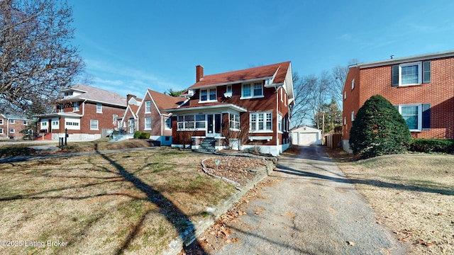 view of front of house with an outbuilding, a garage, and a front yard