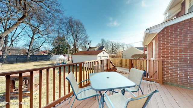 wooden deck with a lawn and a storage unit