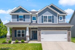 craftsman house featuring a garage and a front lawn