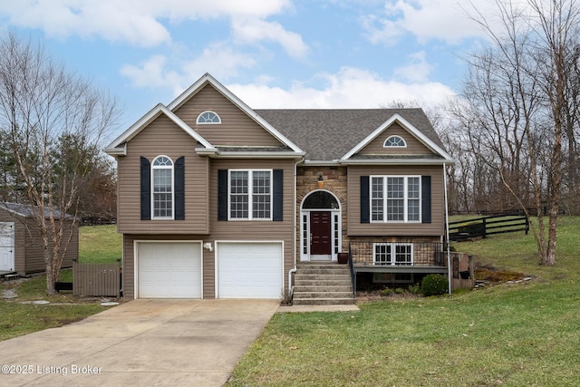 raised ranch featuring a garage and a front lawn