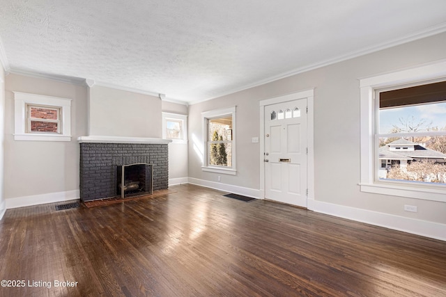 unfurnished living room with crown molding, dark wood-type flooring, a textured ceiling, and a fireplace