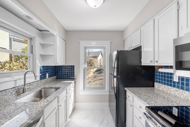 kitchen with stainless steel appliances, plenty of natural light, sink, and white cabinets